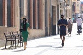 Una mujer se protege del sol con un abanico en la calle portales de Logroño.