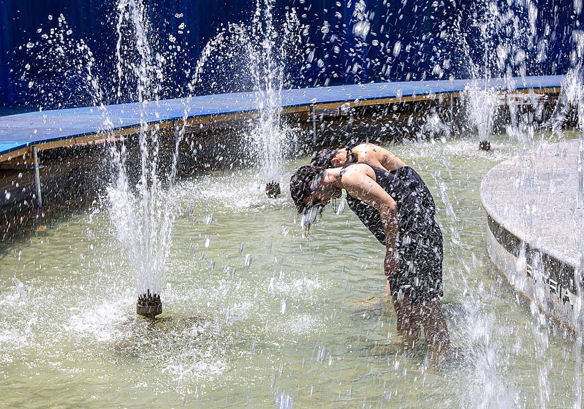 Dos jóvenes tratan de refrescarse en una instalación de Concéntrico.