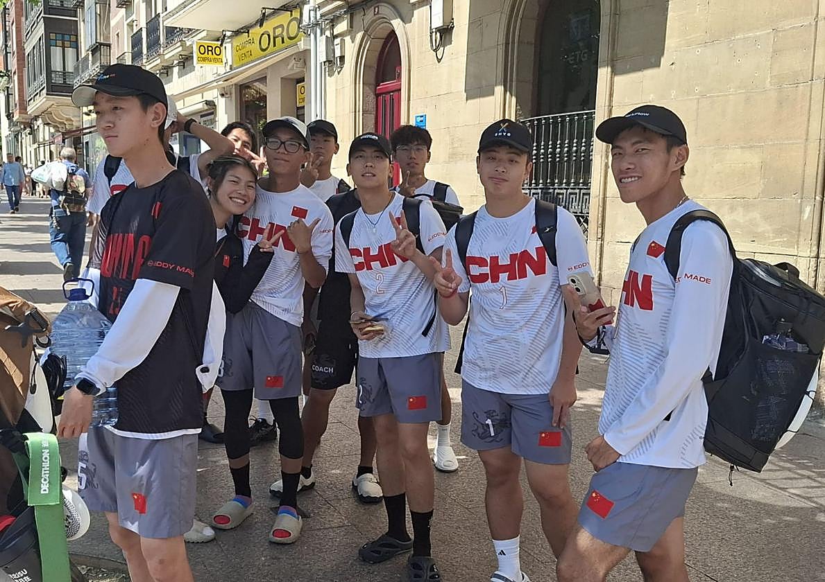 Un grupo de jugadores de la selección de China esperan en la parada del autobús urbano.