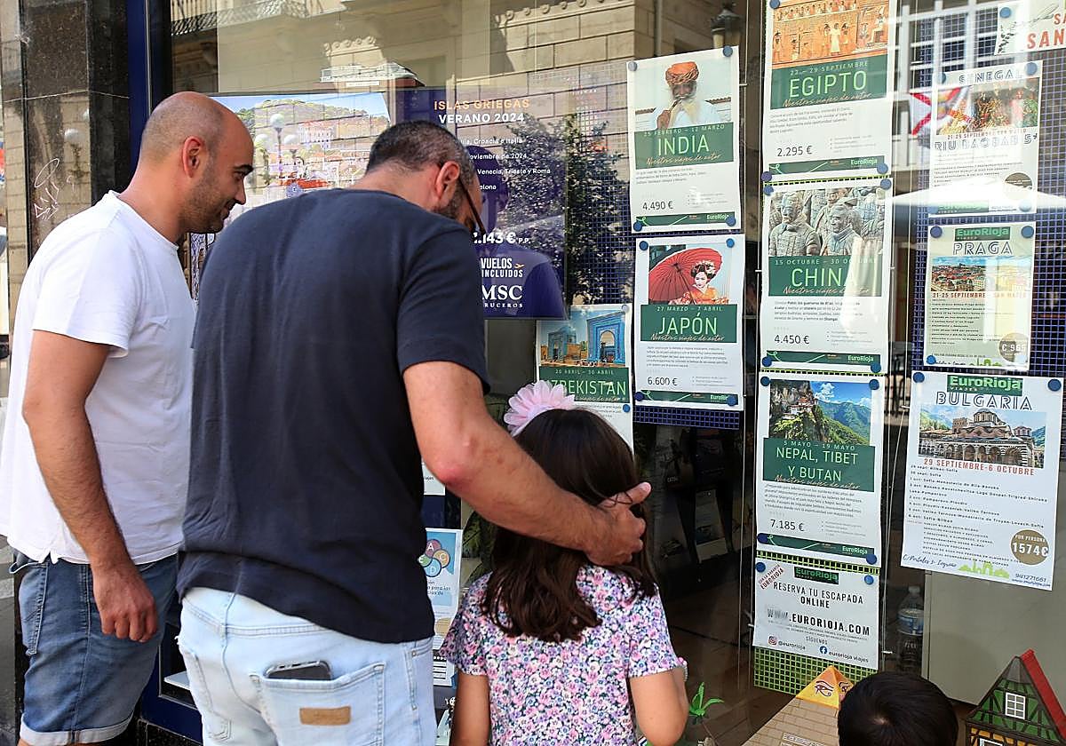 Unos viandantes miran el escaparate de una agencia de viajes en Logroño.