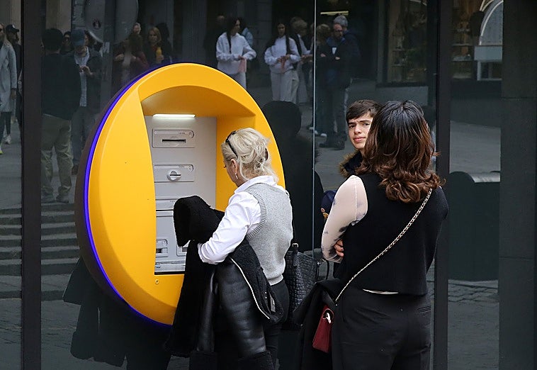 Una mujer opera en un cajero automático.