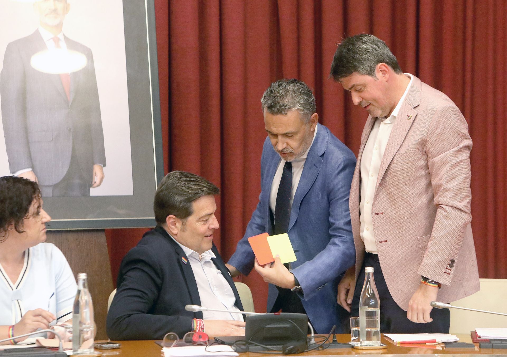El alcalde Escobar, tarjetas roja y amarilla en la mano, conversa con concejales del PSOE antes del inicio del pleno de julio.