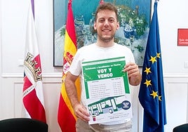 El concejal de Juventud, Iván Jiménez, con un cartel del servicio de autobús 'Voy y vengo' a las fiestas de verano.