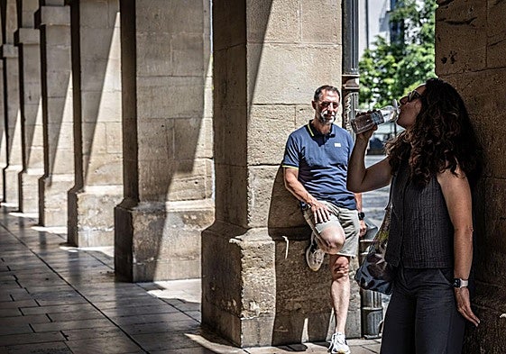Dos paseantes, en los portalillos de la Plaza del Mercado durante la última ola de calor