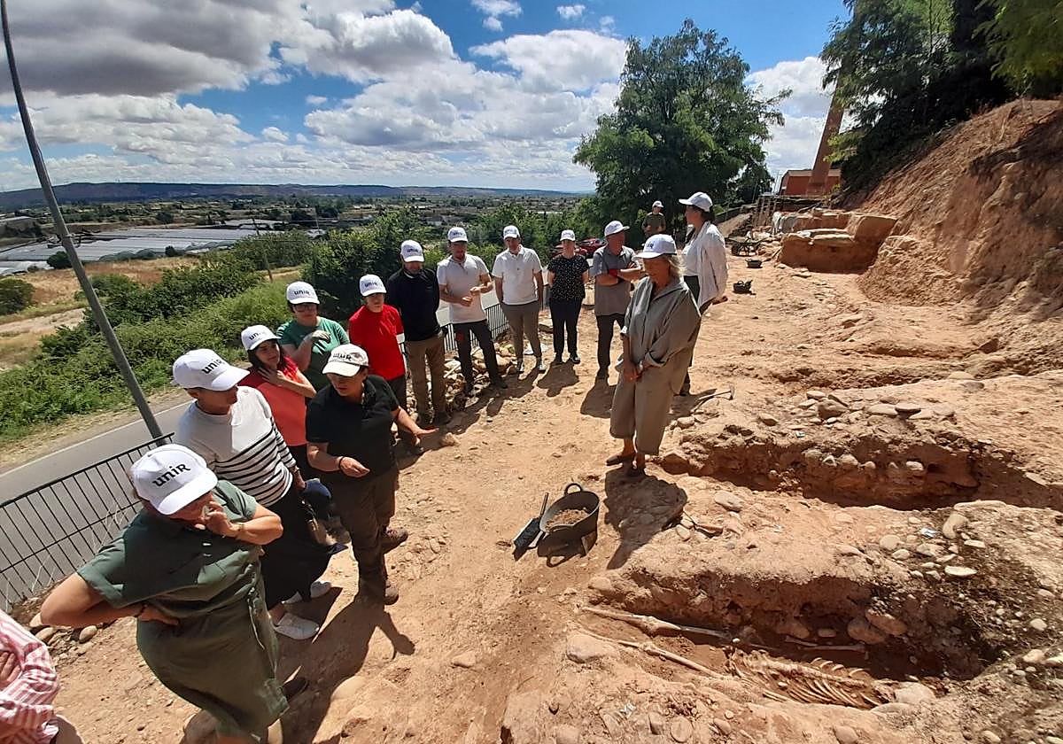 Alumnos y autoridades, este lunes, junto a varios enterramientos del yacimiento 'La Clínica' de Calahorra.