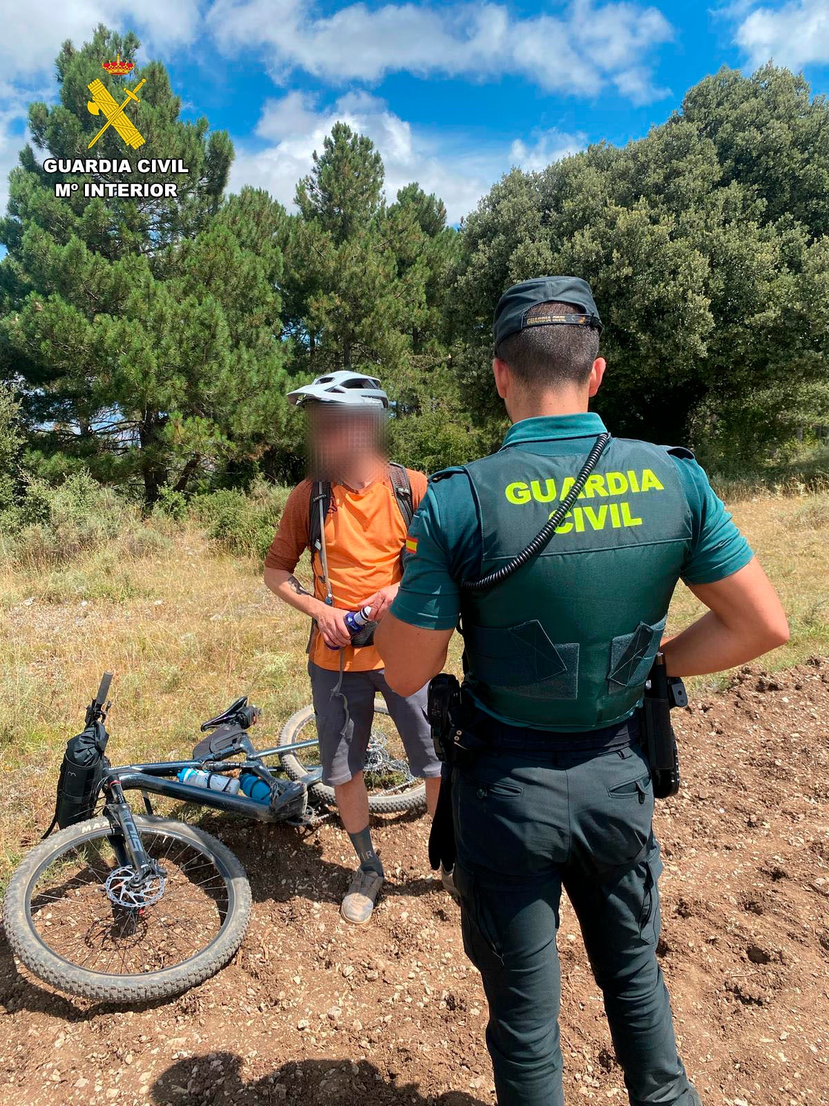 El ciclista junto a uno de los agentes que le ha auxiliado.
