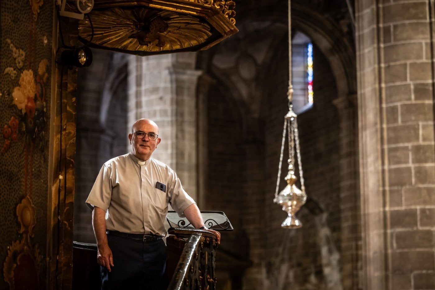 El párroco de Navarrete, Armando Lasanta, posa en un púlpito de la iglesia de la Asunción con el incensario al fondo.