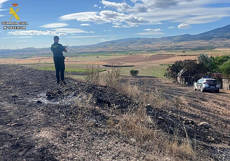 Un agente de la Guardia Civil fotografía la zona del incendio en Ribafrecha.