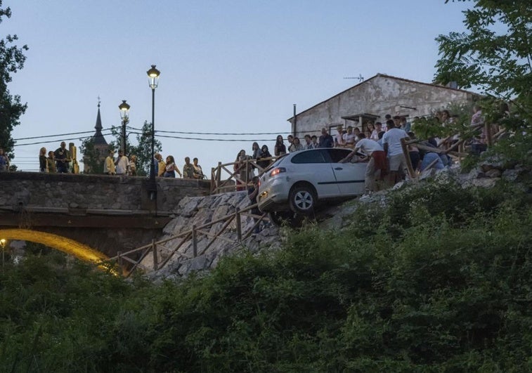 Varias personas ayudan para evitar que el vehículo caiga al río Leza.
