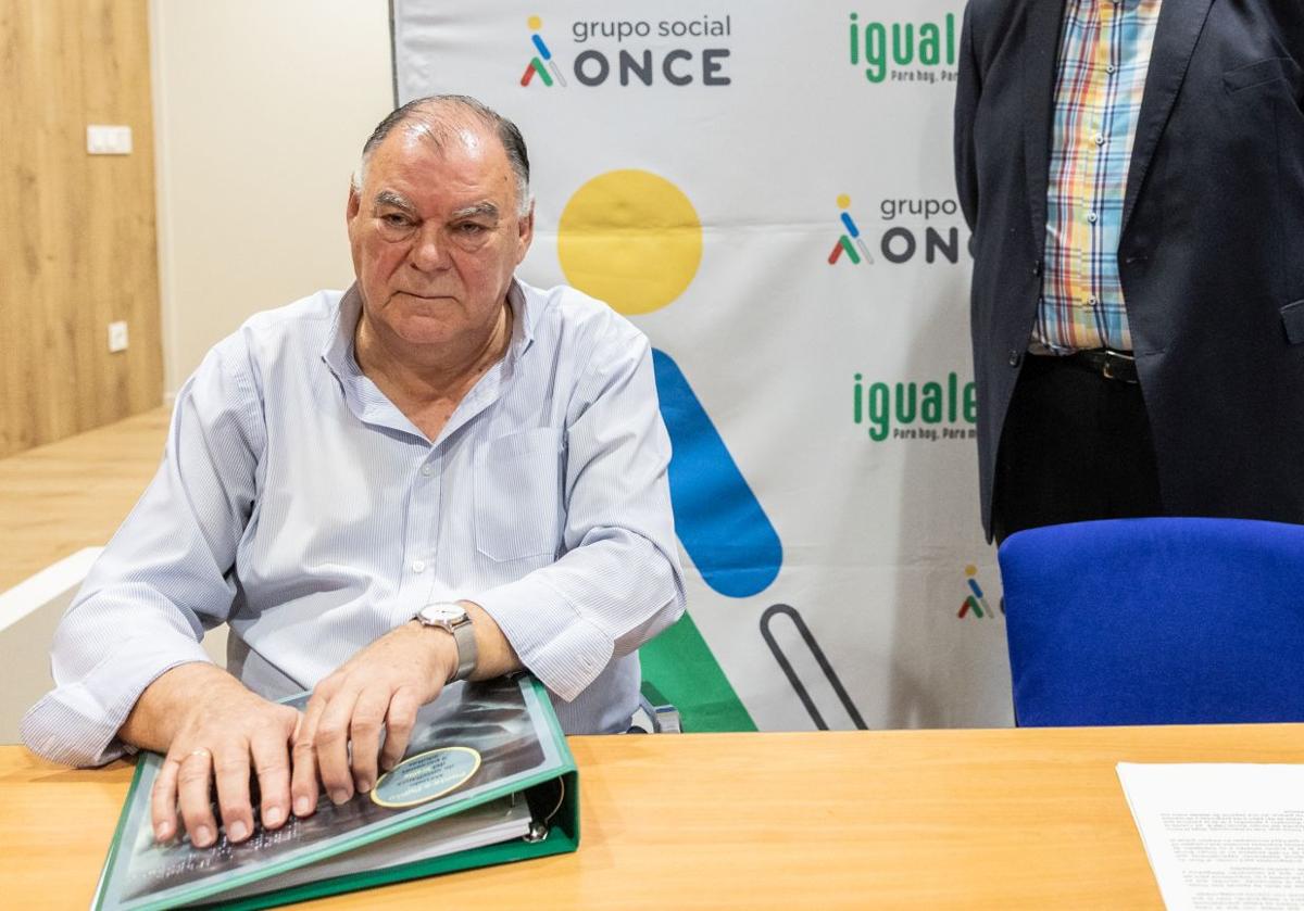 Pelayo Fernández leyendo una portada en braille.