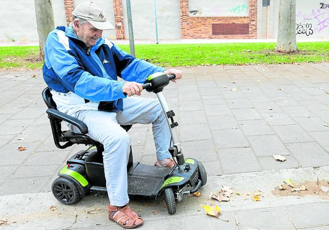 Félix Ruiz maniobra para atravesar un canal de paso de agua presente en parques y plazas que atasca su moto.