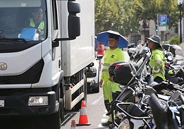 Unos trabajadores se protegen la cabeza del sol.