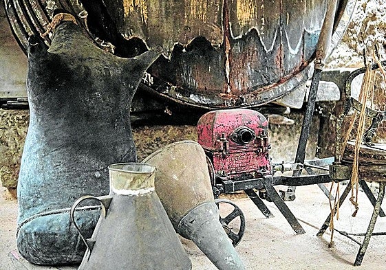 Un fudre de madera con una cántara y un pellejo para transportar el vino.