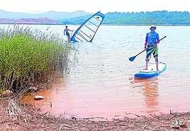 Dos aficionados a paddel surf y windsurf, en la orilla del pantano del Perdiguero.