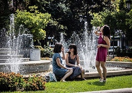 Unas jóvenes se refrescan junto a la fuente de El Espolón.