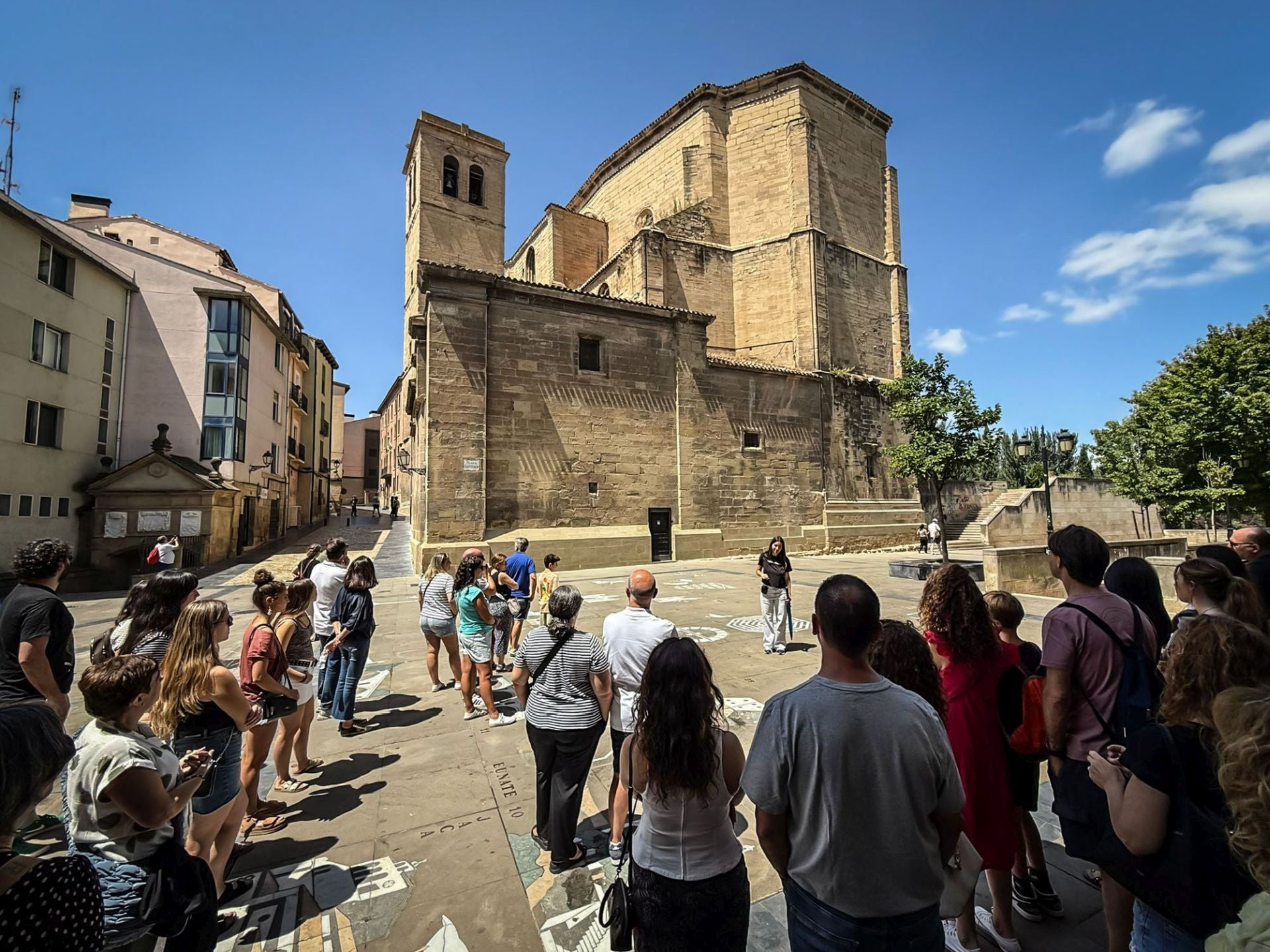 Un grupo de turistas atiende las explicaciones de una guía el pasado mes de julio junto a la iglesia de Santiago de Logroño.