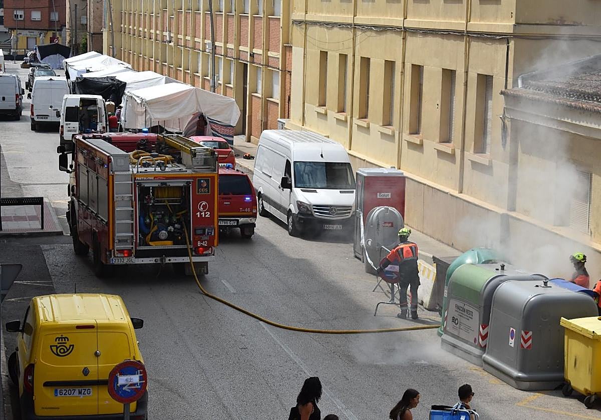 Los bomberos intervienen para apagar el fuego en el contenedor.