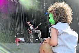 Una niña asiste al concierto de Los Bengala en el MUWI en primera fila, subida a hombros de su padre.