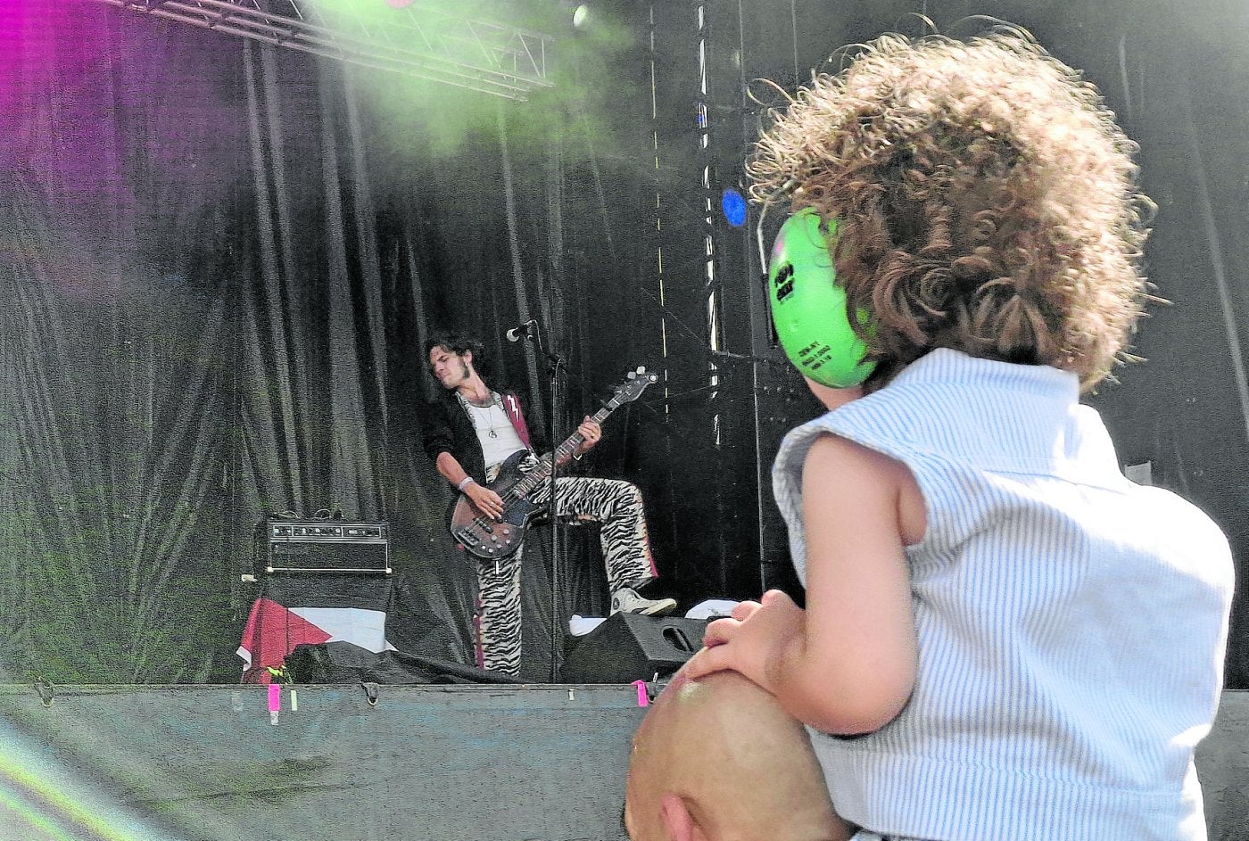 Una niña asiste al concierto de Los Bengala en el MUWI en primera fila, subida a hombros de su padre.
