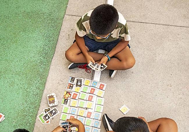 Dos menores juegan sentados en un parque.