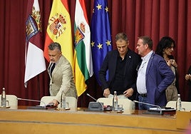 Escobar tomando asiento, con Sáinz e Iglesias a un lado.