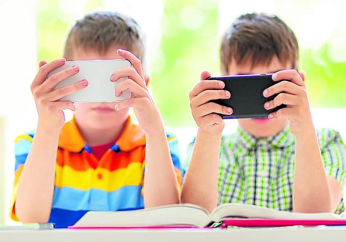 Un grupo de móviles observa el móvil mientras estudia.