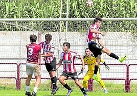 La defensa de la SD Logroñés despeja un balón aéreo mientras Kike Royo observa la jugada ante el Alfaro en pretemporada.
