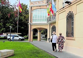 Una pareja pasea ante el bar de La Baronesa, con un vehículo de la brigada de obras en su entrada.