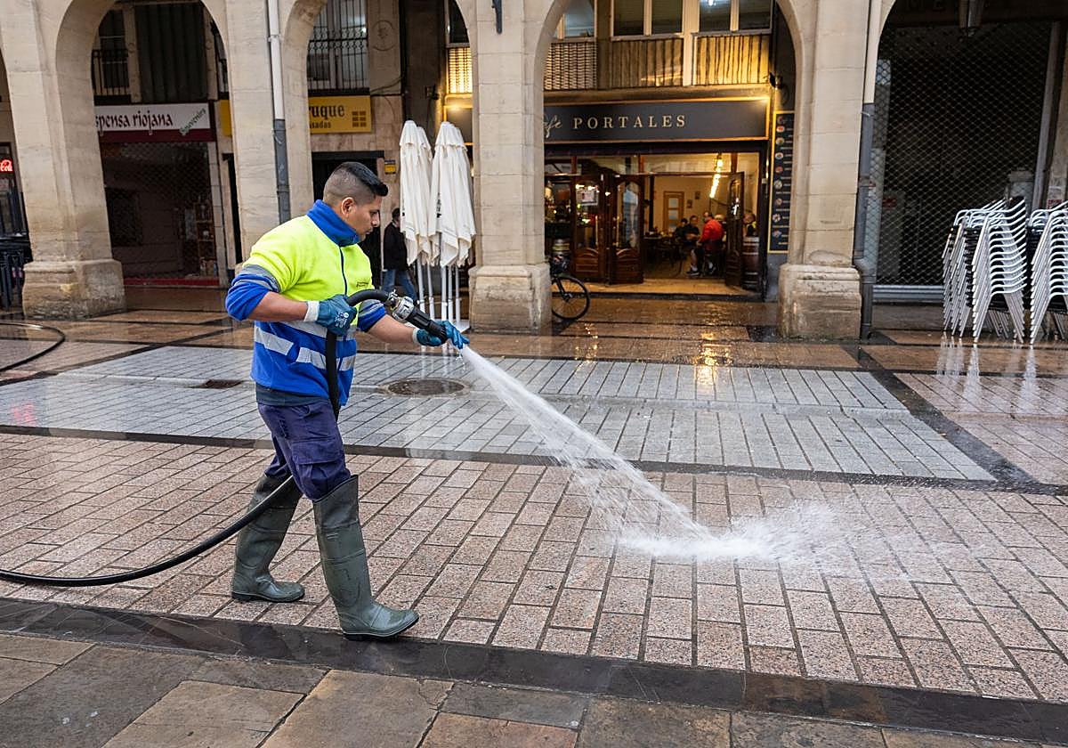 Un trabajador de Logroño Limpio baldea el suelo en la calle Portales.