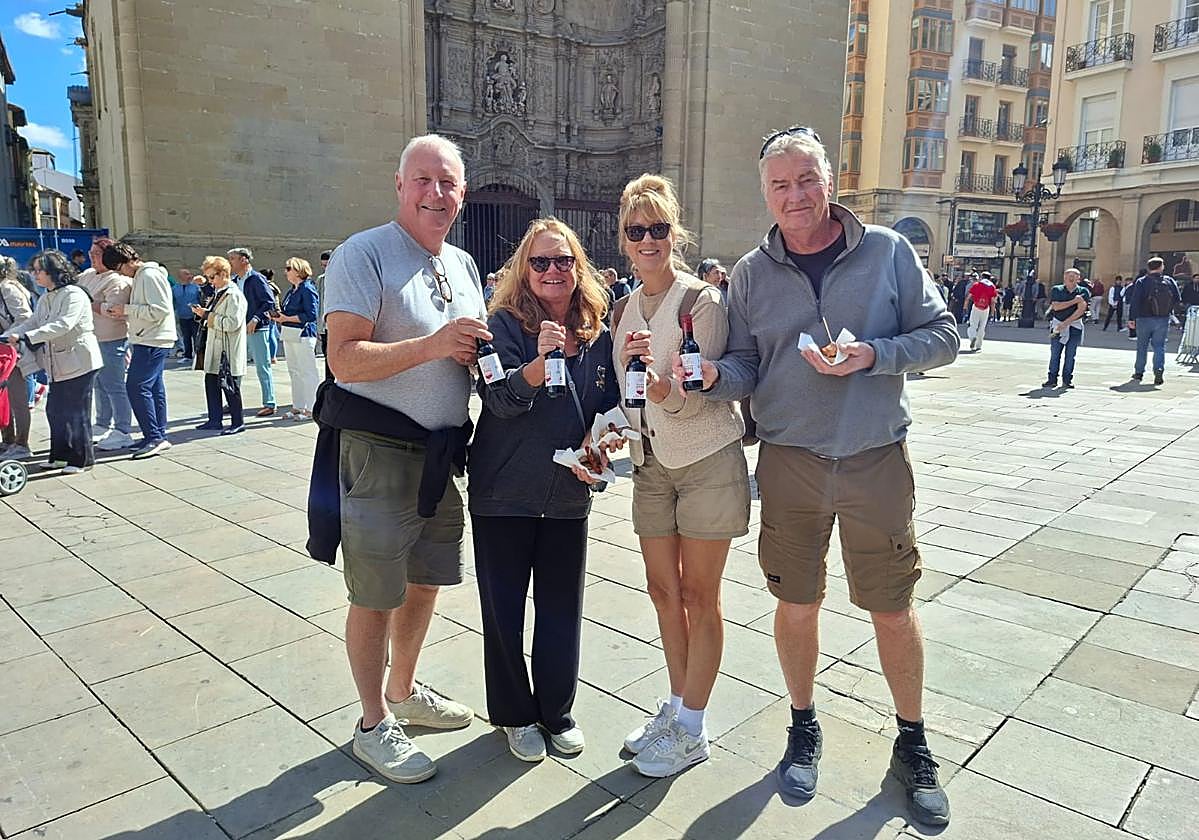 Los cuatro británicos, con su pincho de choricillo y panceta y sus botellas de vino.