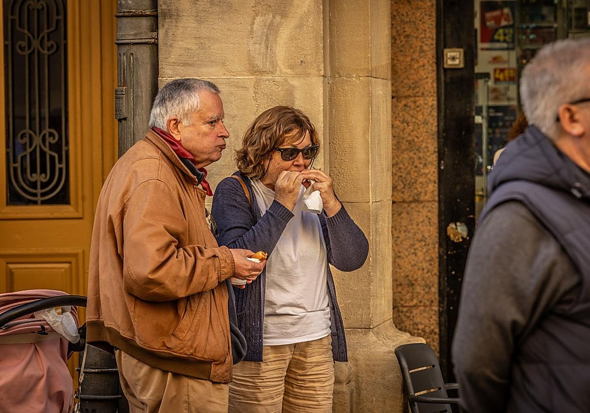 Una pareja degusta el pincho solidario de Cáritas.