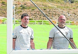 Unai Mendia y Aarón Ruiz, responsable de material, transportan una portería.