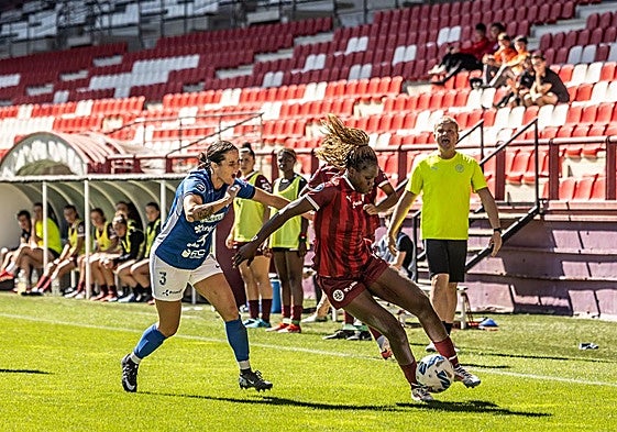 Flavine controla el esférico presionada por Nuria.