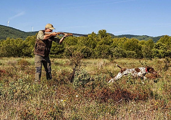 Un cazador practica caza menor junto a su perro.