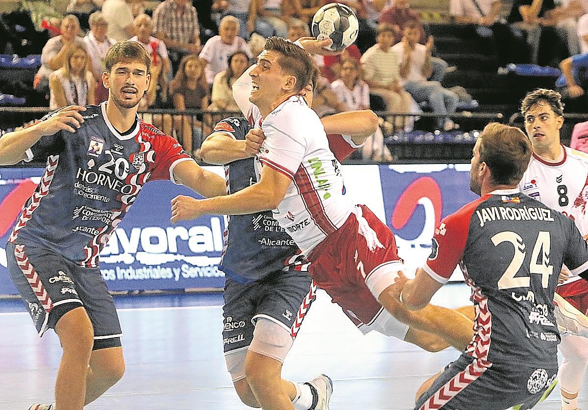 Álvaro Preciado lanza en salto a portería entre la defensa del Eón Alicante.