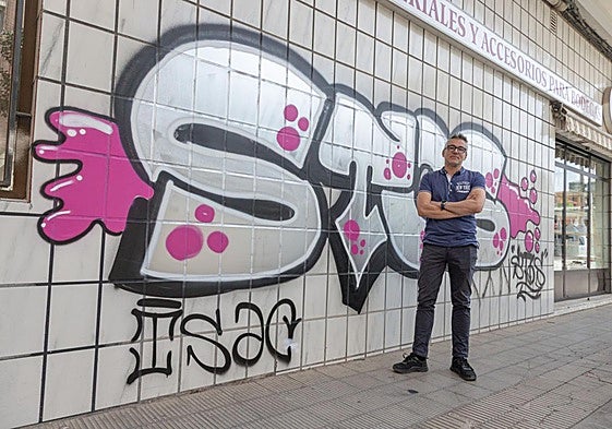 Gerardo Sáenz de Cabezón posa, resignado e impotente, ante la pared pintada de su tienda en la calle Villamediana de Logroño.