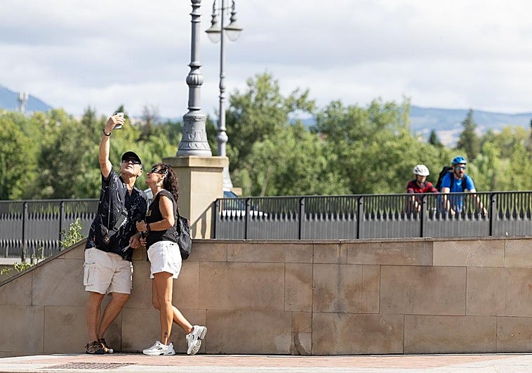 Una pareja de turistas se tira un selfi en el Puente de Piedra de Logroño.