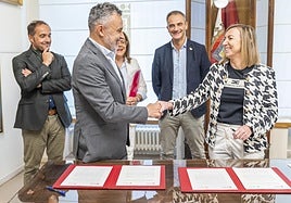 Conrado Escobar y Eva Sanz se saludan tras la firma del convenio en presencia de Eduardo Fonseca, Cristina Olarte y Miguel Sainz.