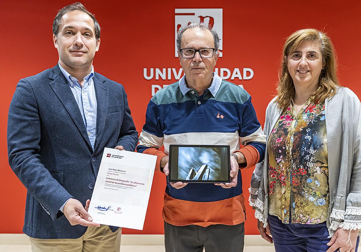 El vicerrector Eduardo Fonseca y la profesora Esther Raya entregan a José Reyes Belzunce el premio del Concurso de Fotografía por la imagen que protagoniza el cartel del congreso.