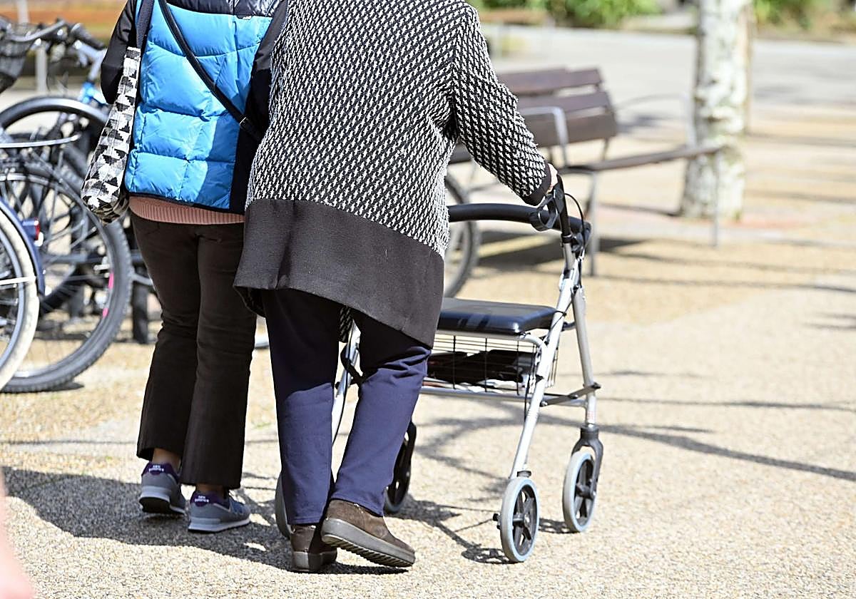 Una anciana camina con su andador.