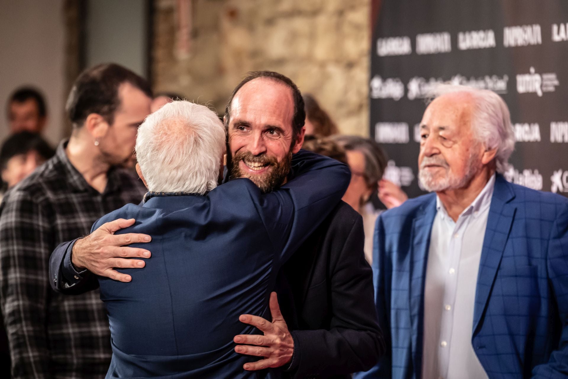Eduardo Sáenz de Cabezón, de frente, se abraza efusivamente con Jesús Vicente Aguirre, de espaldas.