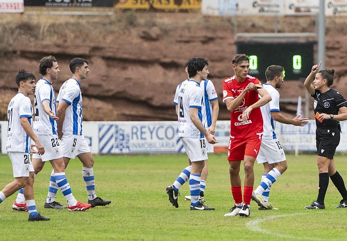 Con nueve. La colegiada, Elisabeth Calvo, con la roja en la mano para expulsar a Merino; después hizo lo mismo con Viti.