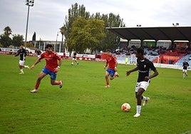 Basir, de la UD Logroñés B, lleva el balón perseguido por los rojillos Bassam y Abel.