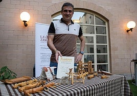 El arqueólogo José María Tejado posa con las tallas elaboradas por su padre y el libro 'Rastros' en la Biblioteca de La Rioja.