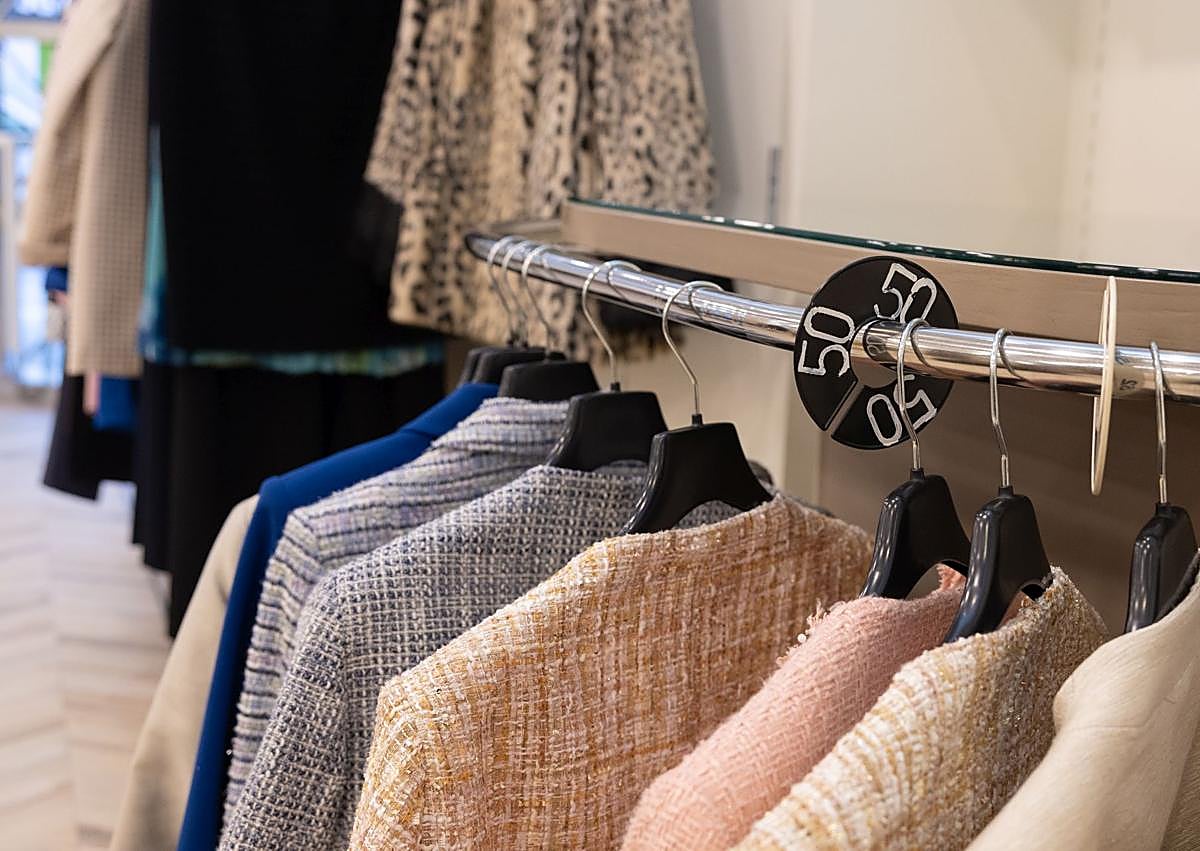 Imagen secundaria 1 - Dos detalles del stock de la tienda y Natalia colocando un collar en el escaparate.