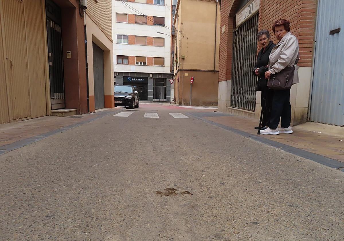 Dos vecinas observan el excremento reseco de una mascota tras días sin ser recogido.