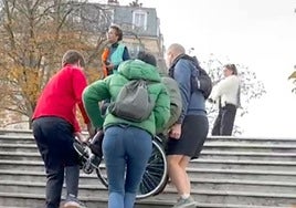 Dos viajeros ayudan a Izaskun a subir a su marido, Kity, por las escalares del metro de París, para poder salir de allí.