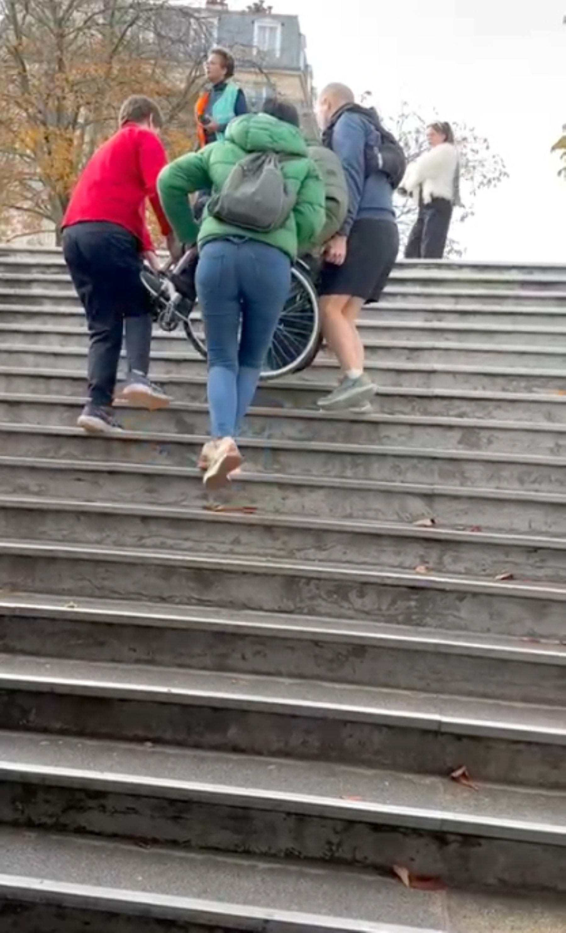 Dos viajeros ayudan a Izaskun a subir a su marido, Kity, por las escalares del metro de París, para poder salir de allí.