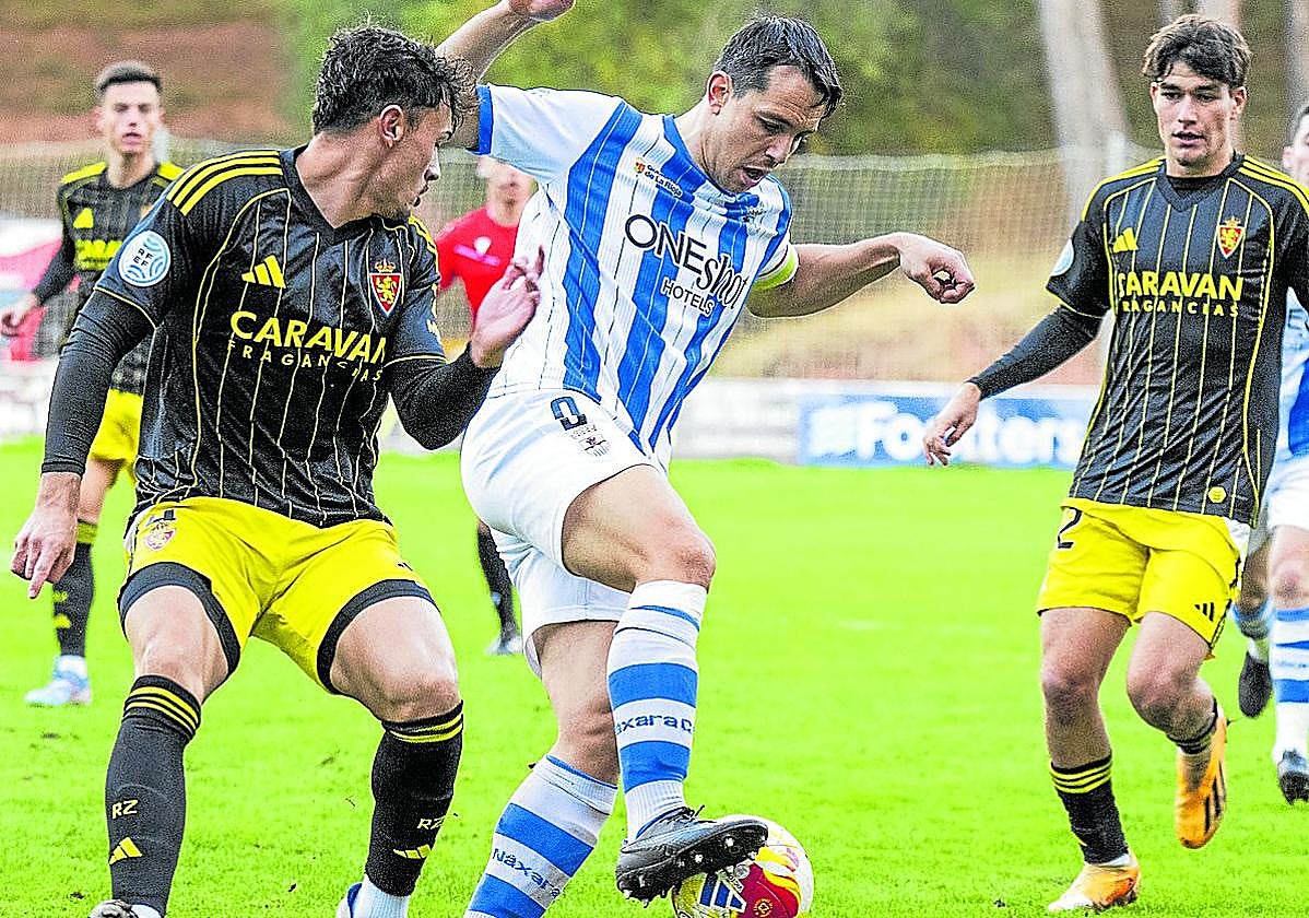 Orodea controla el esférico presionado por un rival del Deportivo Aragón en La Salera.