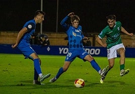 Javier Caño golpea el esférico ante la presión de dos jugadores del Amorebieta.